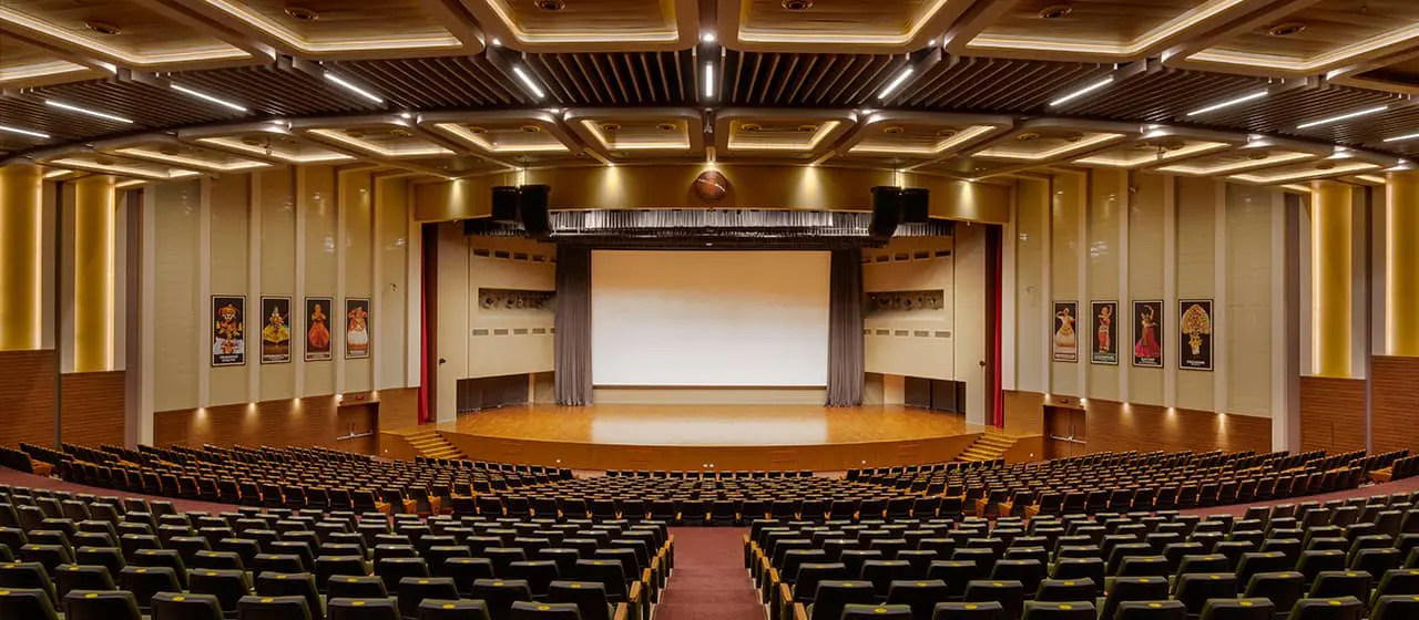 An auditorium with rows of chairs and a stage featured in the Guide to Auditorium Lighting - The Ultimate Guide to Auditorium Lighting - Vorlane - Vorlane An auditorium with rows of chairs and a stage featured in the Guide to Auditorium Lighting - The Ultimate Guide to Auditorium Lighting - Vorlane - Vorlane